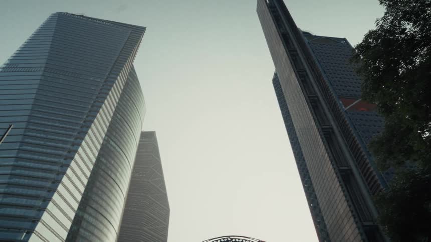 A slow pan reveals towering modern skyscrapers in a city's business district from a low-angle perspective
