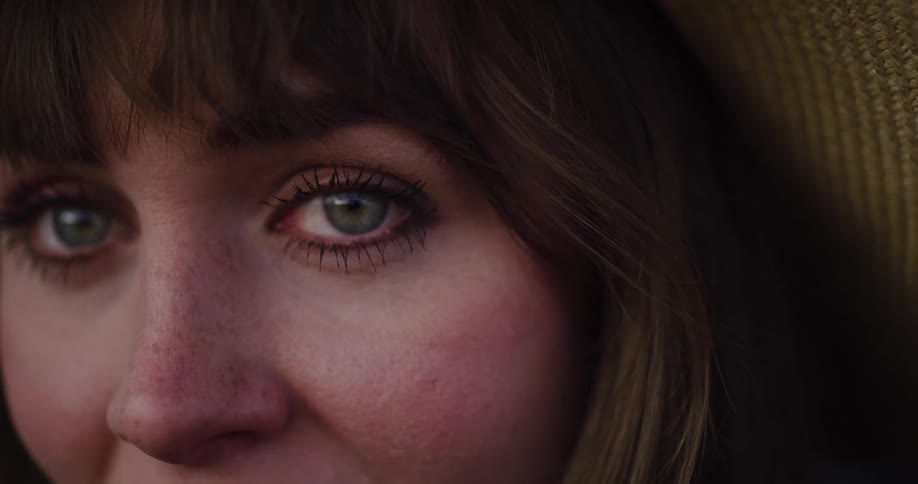 A close-up shot of a young woman's green eyes as she stares pensively into the camera
