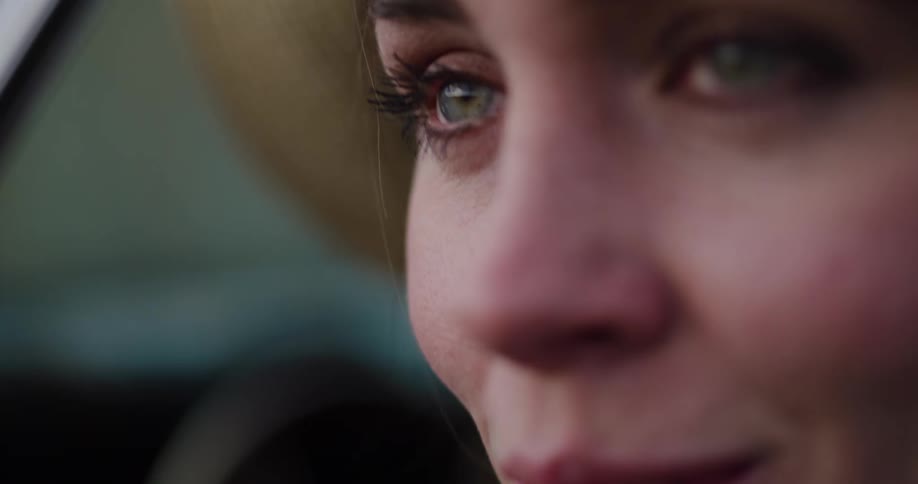 An emotional close-up of a sad woman's green eyes as a single tear rolls down her face