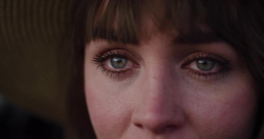 An extreme close-up of a sad woman's beautiful green eyes as they begin to fill with tears