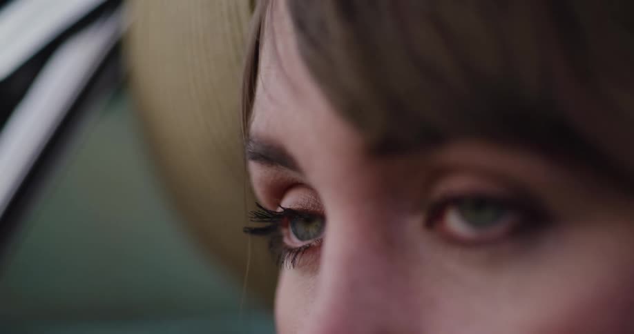 A close-up shot of a sad woman's green eyes as a single tear rolls down her cheek