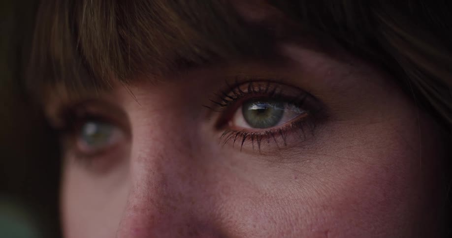 A detailed close-up shot of a woman's beautiful green eyes looking intently off-screen