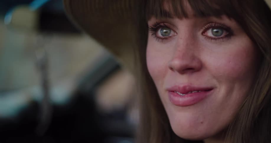 Cinematic close-up of a serene woman in a floppy hat, her green eyes and soft smile conveying a sense of quiet contentment