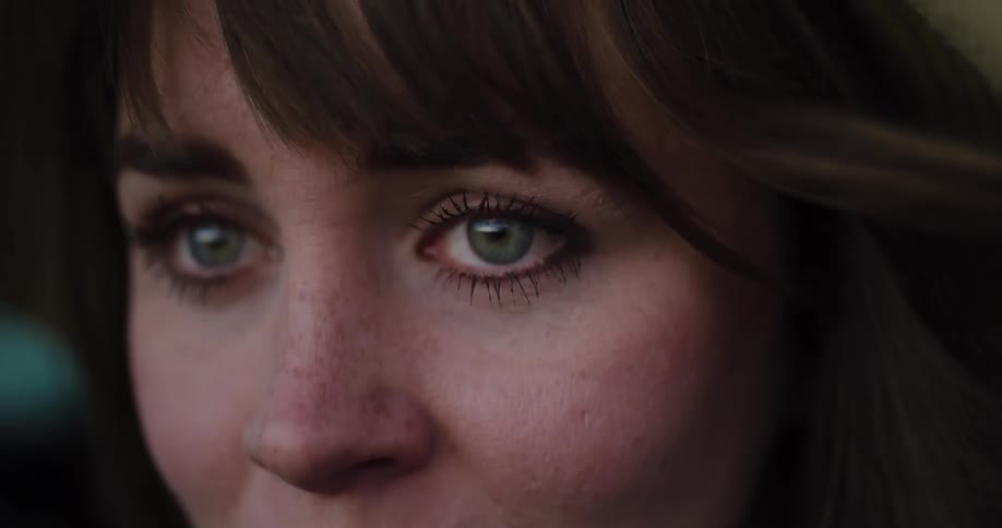 A woman's emotional green eyes well up with tears in a dramatic close-up shot