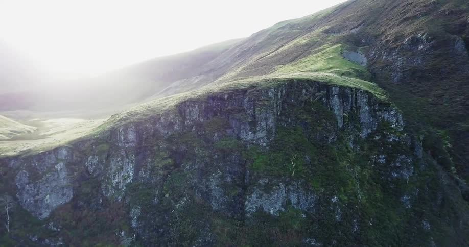 A rocky cliff is shown on a sunny day