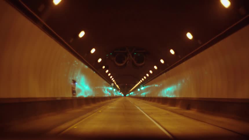 A car is traveling fast down a tunnel
