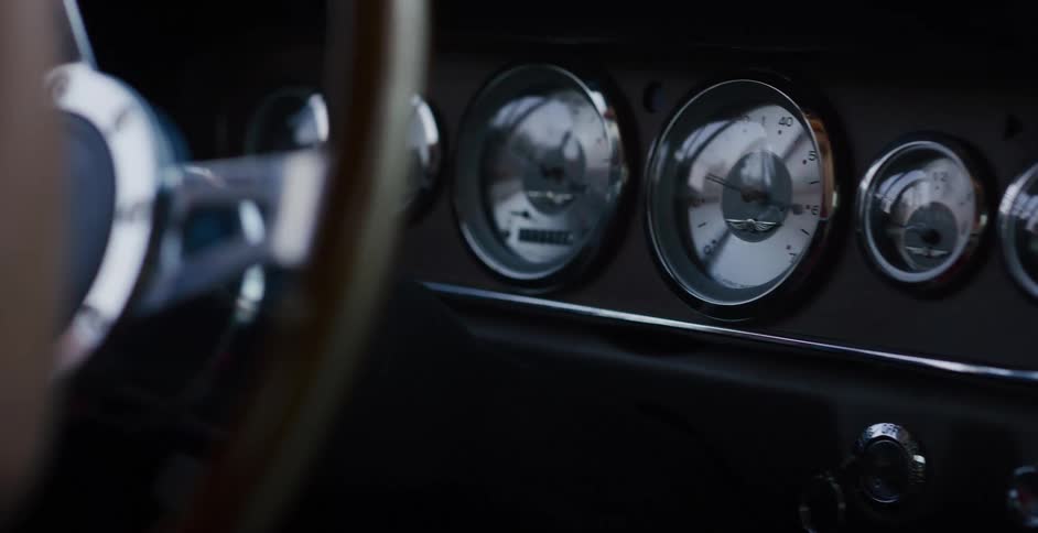 A close-up shot of the chrome gauges and dashboard inside a classic vintage car
