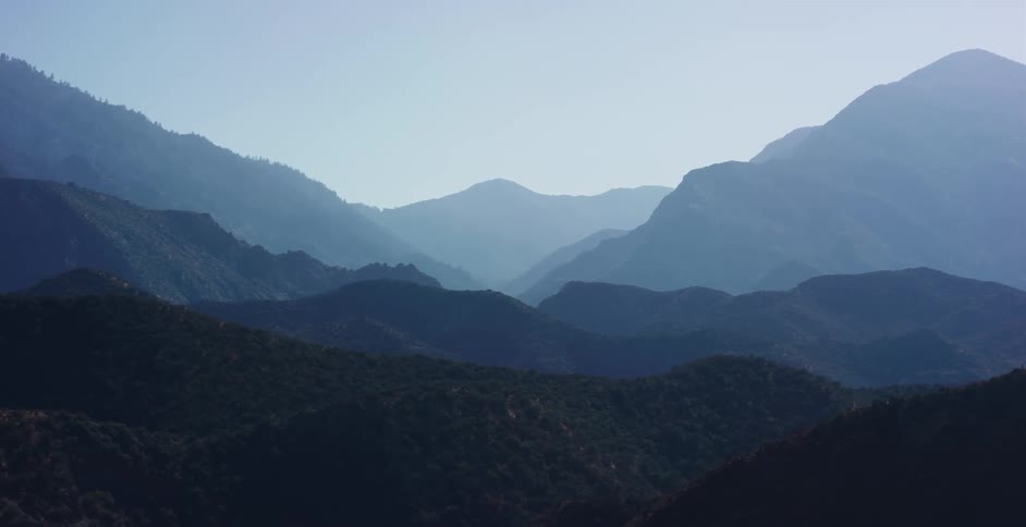 Majestic layers of a hazy blue mountain range create a serene and beautiful natural landscape