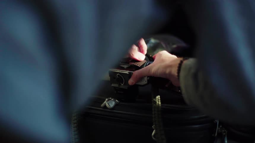 Person putting film into an old camera