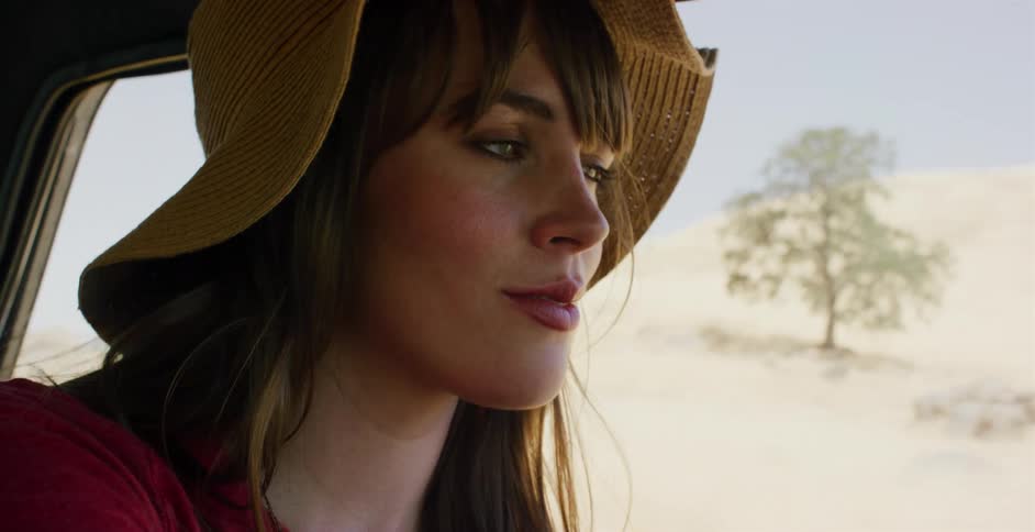 A beautiful woman in a hat enjoys a serene drive through the countryside in slow motion