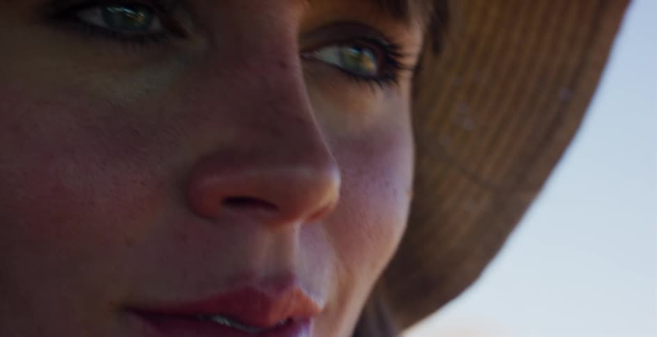 An intimate close-up shot focuses on the serene face and beautiful green eyes of a woman in a hat
