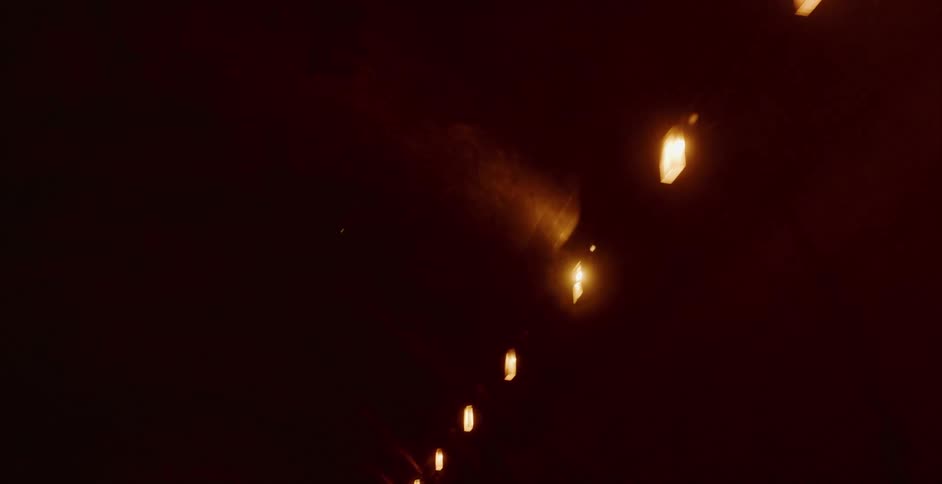 An abstract, low-angle shot of warm ceiling lights passing by inside a dark underground tunnel
