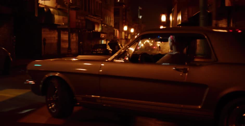 A woman with a retro style drives her classic muscle car through the neon-lit streets of Chinatown at night