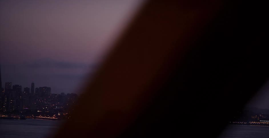 A slow pan reveals the luminous San Francisco skyline at twilight, with the city lights sparkling across the bay