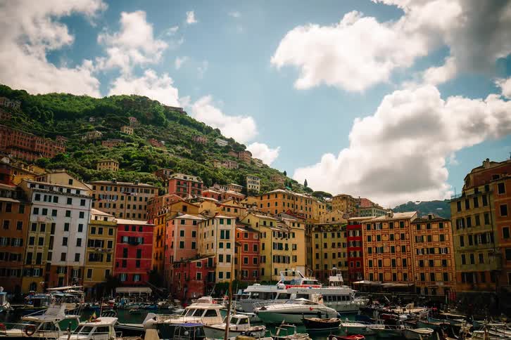 A vibrant timelapse of the picturesque harbor of Camogli, Italy, where colorful buildings line the hillside and boats sway gently in the water