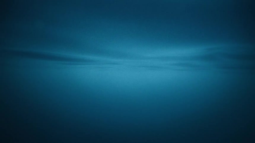 A serene and mysterious view from deep underwater looking up at the gently rippling surface