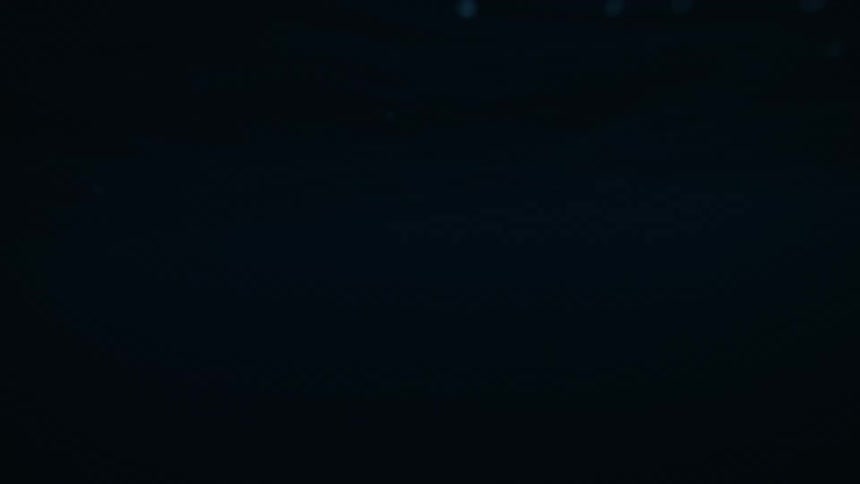 A serene slow-motion split view shows the dark, rolling ocean waves with majestic snow-covered mountains in the distance during twilight