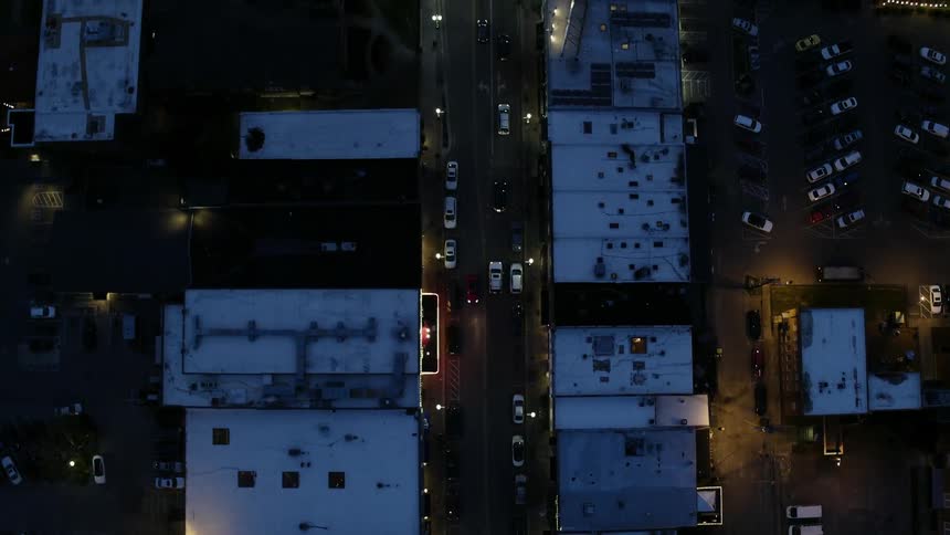 Cars drive on city streets at night