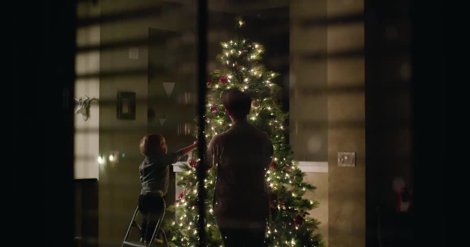 A woman and child decorate a christmas tree