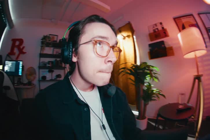 An intense young gamer wearing a headset focuses on playing a video game in his room, shot with a dynamic fisheye lens