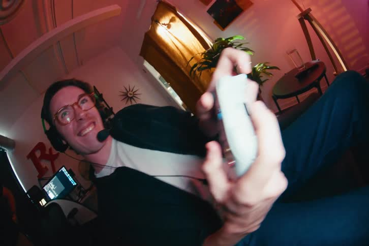 A young gamer with a headset shouts excitedly while playing a video game, seen from a dynamic fisheye perspective