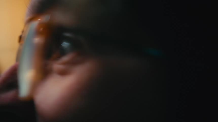 An extreme close up of a man's eye widening in shock and surprise as he watches something intently