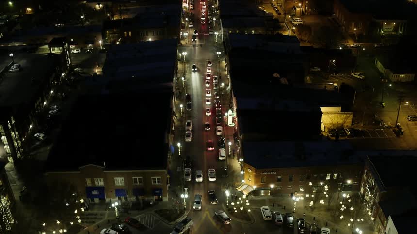 Cars travel down the road at night making turns