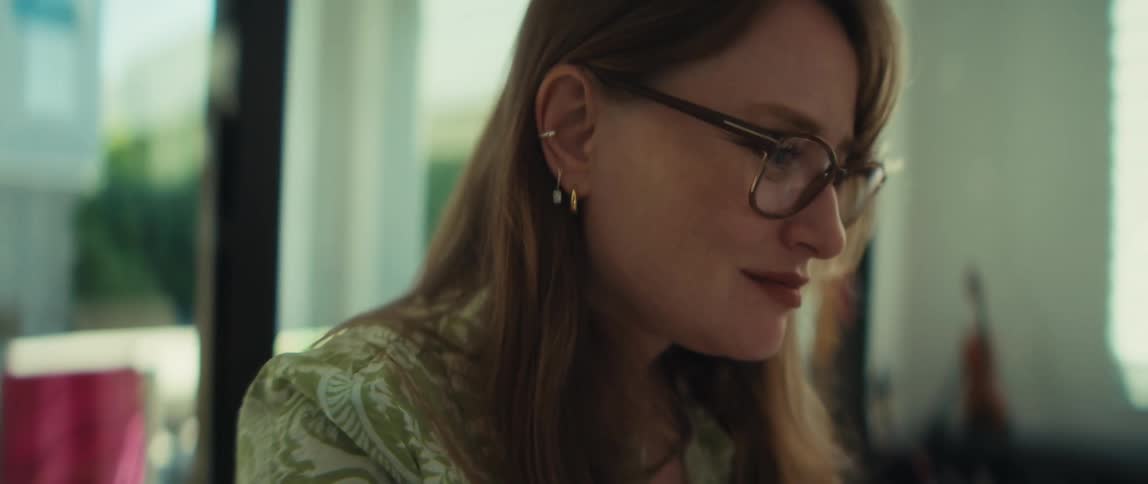 Cinematic close-up reveals a focused young woman working on her laptop in a sunlit room