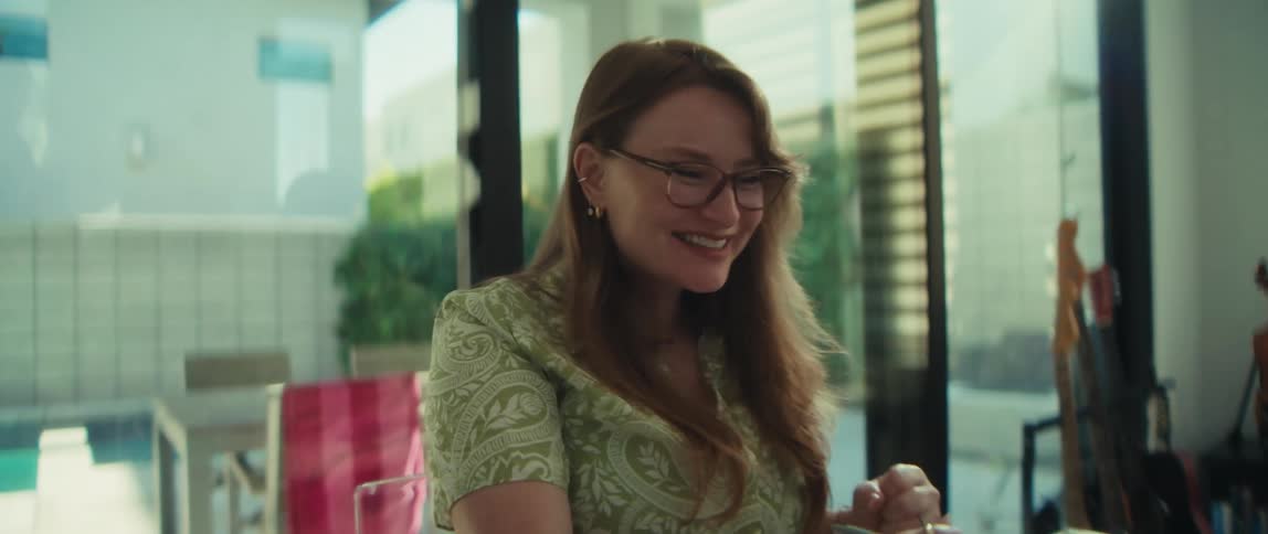 A happy woman working from her modern home office celebrates good news while looking at her laptop