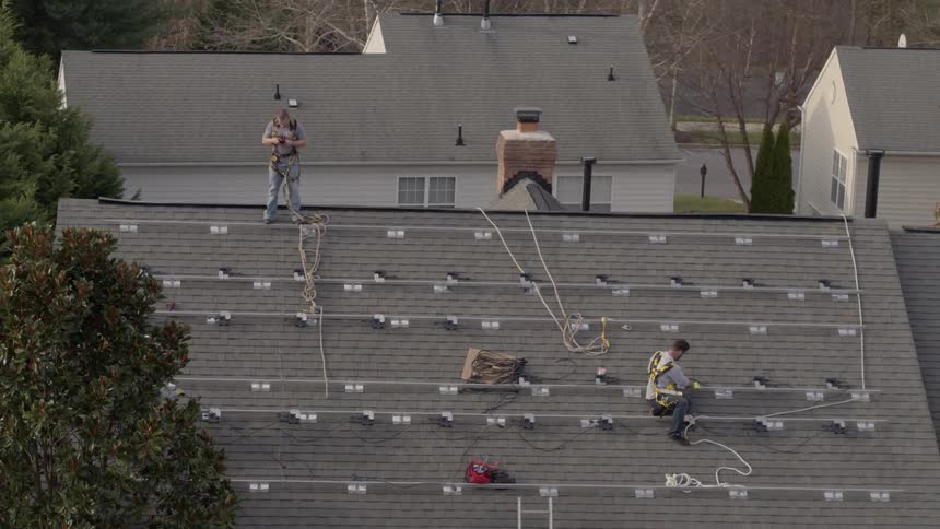 People are working on the roof running wires