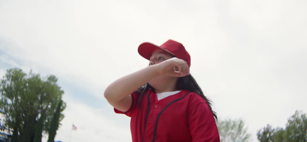 Determined young baseball player in a red uniform makes a catch and throw in slow motion