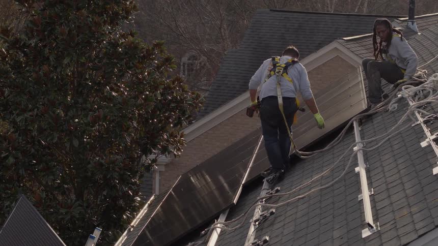 Two men are working on a roof together