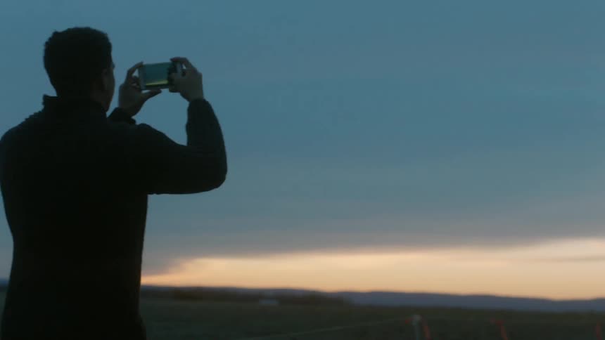 Man takes pictures at sunset