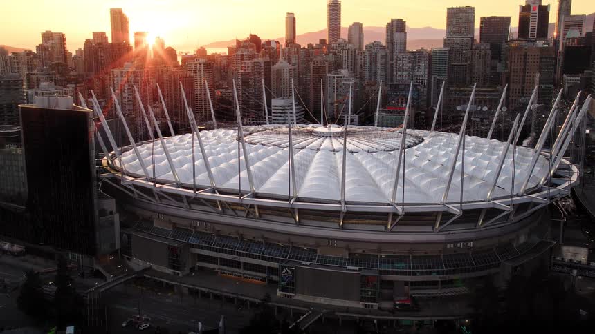 Stunning aerial view of BC Place stadium surrounded by the Vancouver skyline during a golden sunset