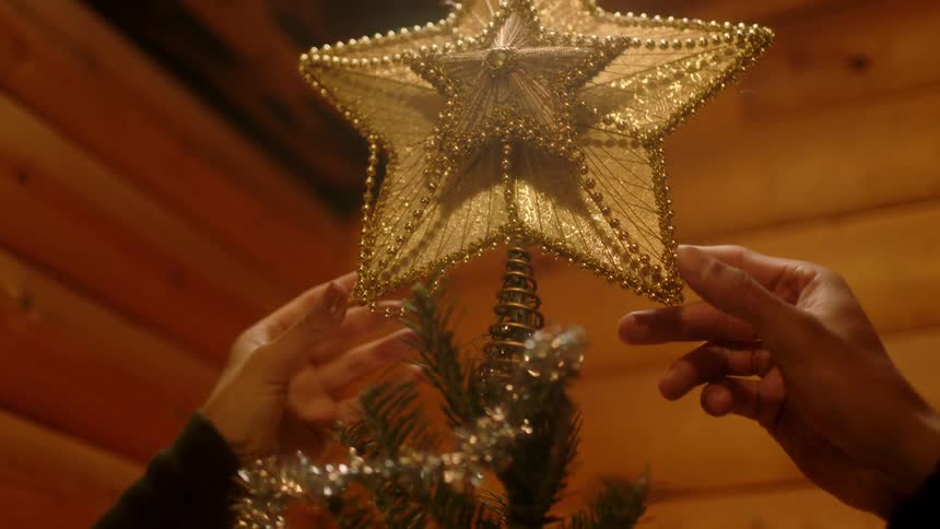 A star is placed on a christmas tree