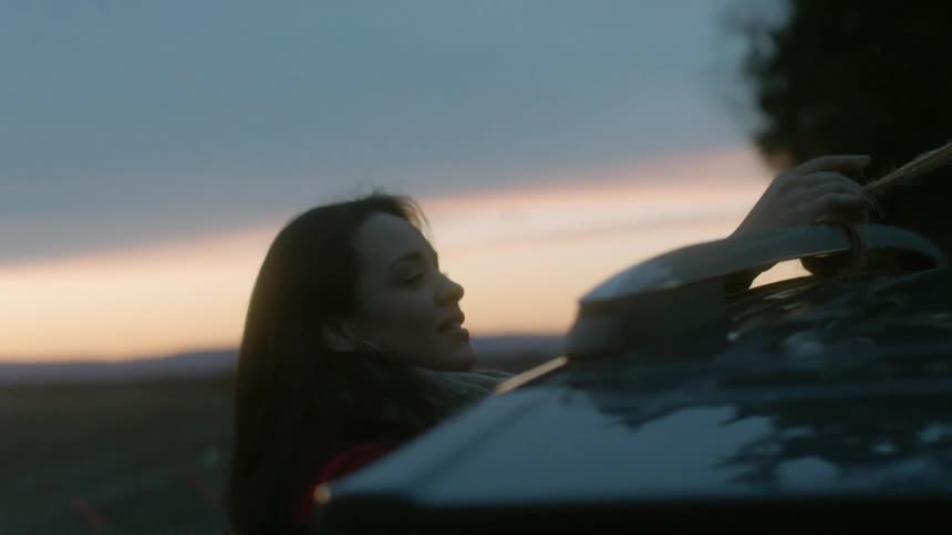 A woman ties a tree to a car
