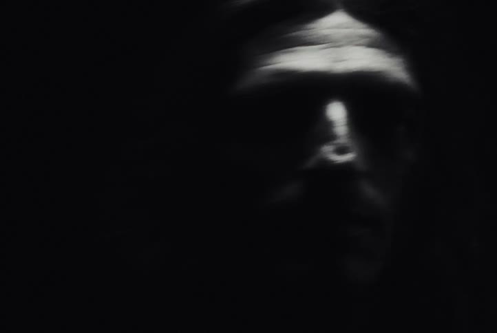 An intense black and white montage captures a man running through the darkness and floating weightlessly underwater