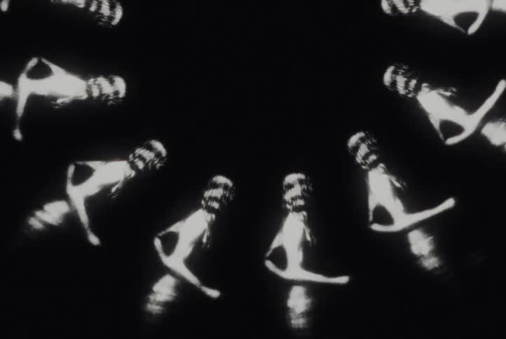 Abstract black and white animation features silhouettes of women forming a rotating kaleidoscope