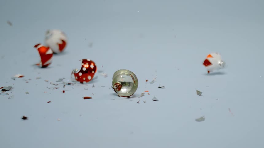 Christmas ornaments falling and shattering to pieces on the ground
