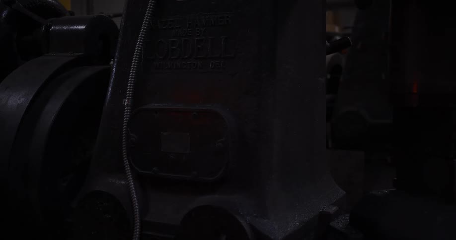 A slow, dramatic zoom reveals the details of a vintage Nazel Hammer in a dark industrial workshop