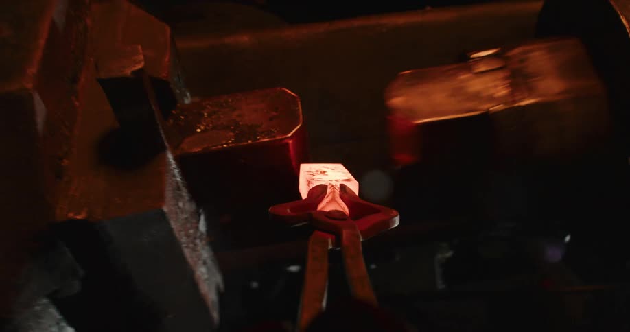 A blacksmith forges hot glowing metal with a power hammer and then carries it in first-person view to a fiery furnace to be reheated