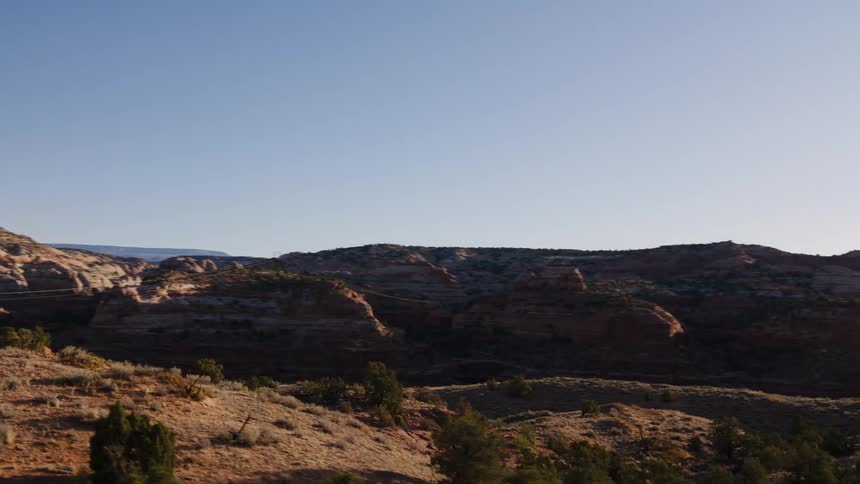 A scenic point-of-view drive along a road through a stunning red rock desert canyon landscape on a sunny day