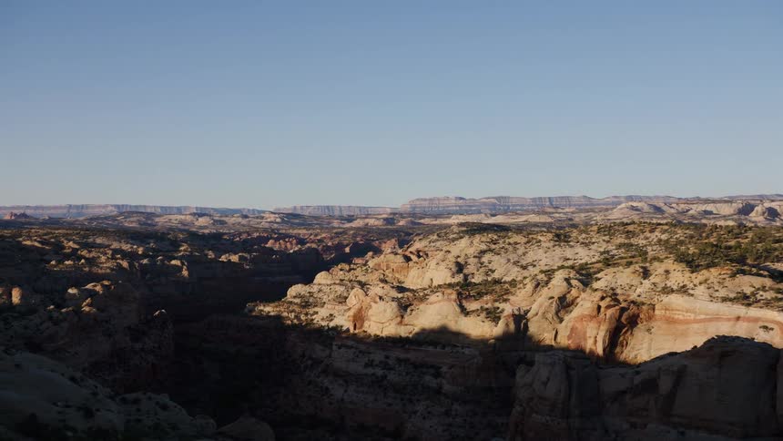 A scenic drive reveals a vast and rugged canyon landscape under a clear blue sky