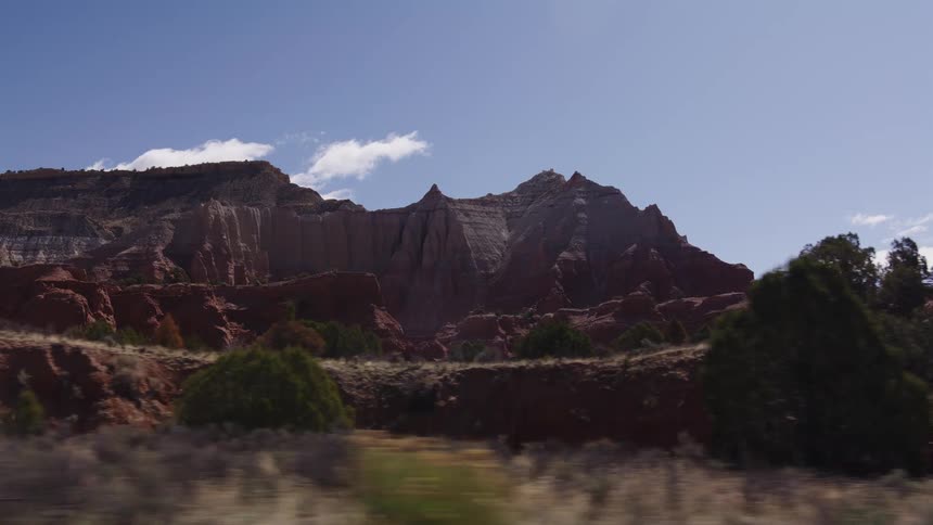A scenic drive past the majestic red rock mountains and desert landscape of the American Southwest on a sunny day