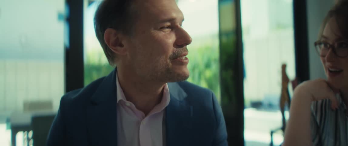 A confident businessman smiles while reviewing positive financial reports during a corporate meeting