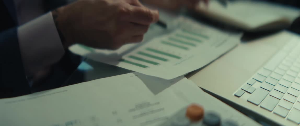 A close-up of business colleagues analyzing financial bar charts during a strategic planning meeting