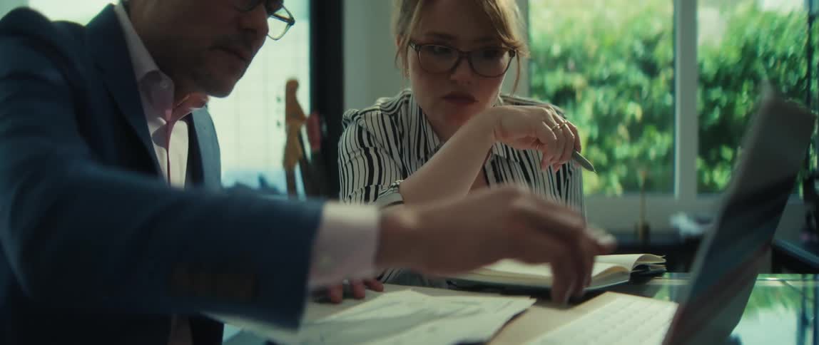 A businessman explains a project on a laptop to his female colleague during a focused meeting in a modern office