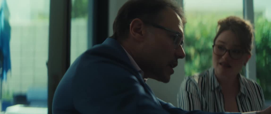 A businessman passionately explains a strategy to his female colleague during a focused meeting in a bright, modern office