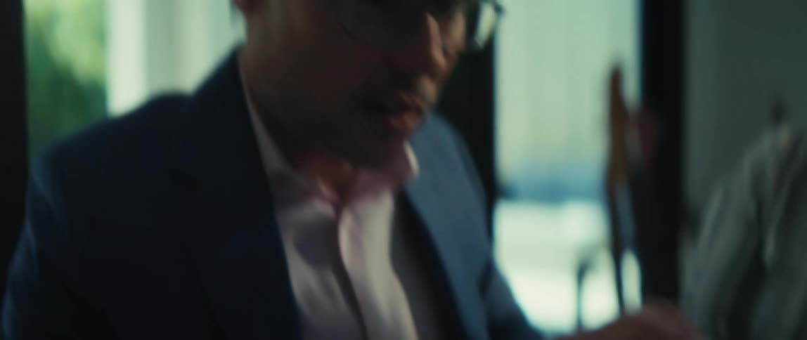 A businessman and businesswoman in a professional office setting collaborate over documents with charts in slow motion
