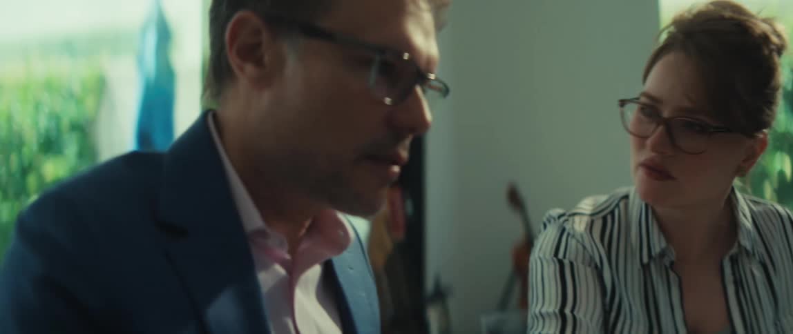 A man and woman collaborate on a business project, pointing at a laptop screen and discussing ideas in a modern office in slow motion